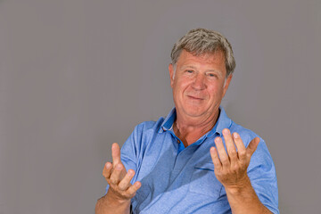 portrait of sixty year old attractive senior man in blue shirt