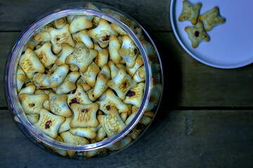 Isolated container of biscuits on wooden table
