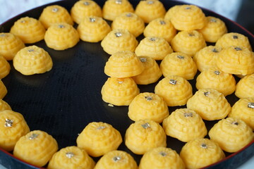 Forcus on center for traditional of Thai sweet dessert, name is Tongeak or Yellow sweetmeats with a piece of gold foil on top, Thailand
