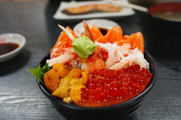 Premium set rice bowl with fresh raw seafood mix, crab, salmon, salmon eggs, uni serve together with wasabi, japanese tasty or kaisen don