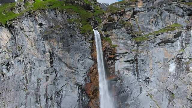 Aerial slow motion: drone flying over scenic high waterfall, mountain stream falling from tall rocky cliff on the italian Alps. Pis waterfall near Torino, Piedmont, Italy