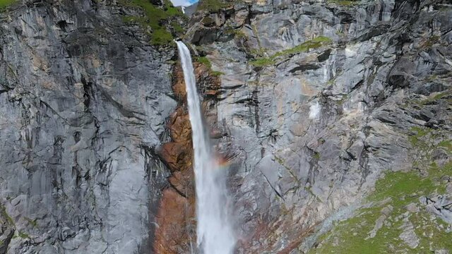 Aerial slow motion: drone flying over scenic high waterfall, mountain stream falling from tall rocky cliff on the italian Alps. Pis waterfall near Torino, Piedmont, Italy