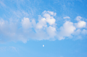 White clouds and moon in blue sky, background. Cirrocumulus clouds