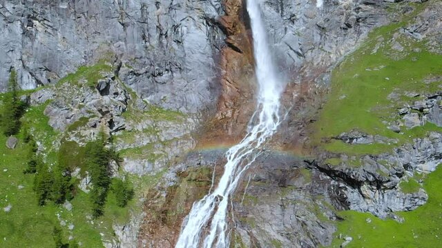 Aerial slow motion: drone flying over scenic high waterfall, mountain stream falling from tall rocky cliff on the italian Alps. Pis waterfall near Torino, Piedmont, Italy