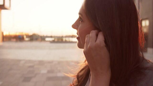 Young attractive business woman sitting outdoor on the bench. Sunset light.