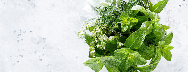 Bunch of aromatic herbs in mortar on kitchen table. Banner - obrazy, fototapety, plakaty