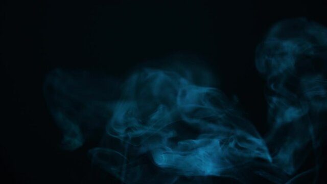 Blue Smoke in Slow Motion. Flowing Abstract Steam in Dark background