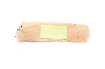 Used antibacterial patch on a white background in macro. Dirty patch, orange yellow top and side view