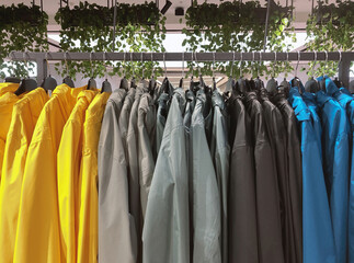 Raincoats on hanging racks in clothing fashion store
