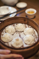 Fototapeta na wymiar chinese dumplings in steamer on table, with utensils on the side