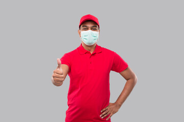 Fototapeta na wymiar Delivery Man Showing Thumb Up Wearing Medical Mask Isolated. Indian Delivery Boy Smiling. Home Delivery.