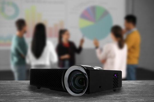 Modern video projector and blurred people on background
