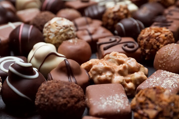 Different delicious chocolate candies as background, closeup