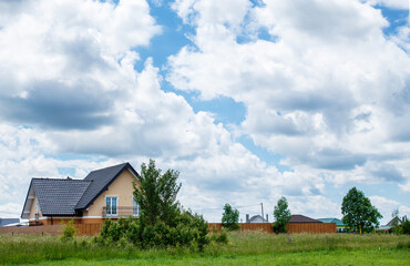 Fototapeta na wymiar new rural house on a background of cloudy sky