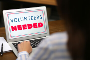 Woman working on modern laptop wooden at table, closeup. Volunteers needed
