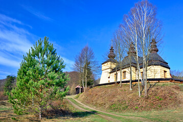 Orthodox wooden church in Kunkowa village near Gorlice in sunny spring day, Low Beskids (Beskid Niski), Poland 

