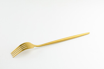 White golden fork on white background
