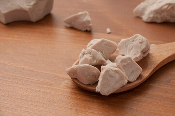 A spoonful of fresh brewer's yeast on a wooden table