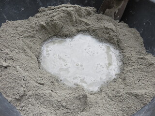 Mixing of sand, water, and Portland cement in powder form which is a basic ingredient of concrete,...