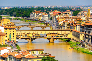 Fototapeta na wymiar It's Ponte Vecchio (Old Bridge), a Medieval stone closed-spandrel segmental arch bridge over the Arno River, in Florence, Italy. View from the Michelangelo Square