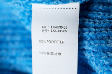Clothing label with material content on blue sweater, closeup view