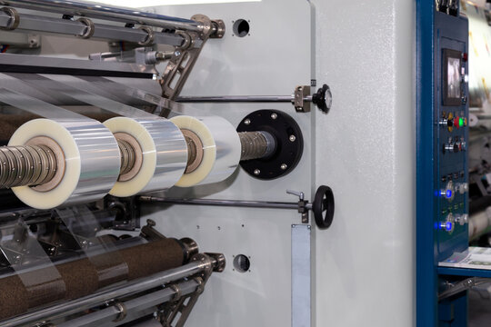 roll of plastic packaging film on the automatic packing machine in food product factory. industrial and technology concept.
