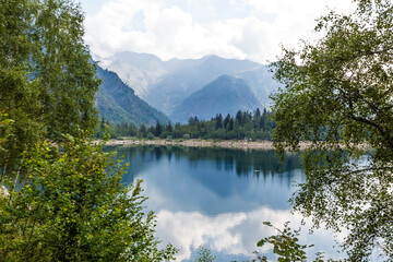 alpine high mountain lake, coniferous woods are reflected in the water, Antrona valley Campliccioli lake, Italy Piedmont
