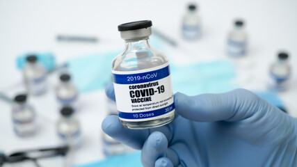 Covid-19 Corona Virus 2019-ncov Vaccine vials medicine drug ampoule bottle closeup syringe injection medical nitrile gloves mask glasses. Vaccination, treatment to cure Covid 19 Corona Virus infection