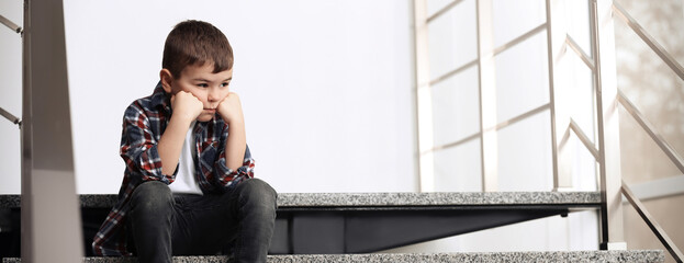 Sad little boy sitting on stairs indoors, banner design with space for text. Time to visit child...