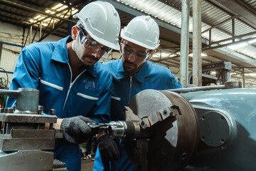 Engineering man wearing uniform safety workers perform maintenance in factory working machine lathe...