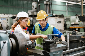 Man and woman engineer industry worker wearing hard hat in factory,
