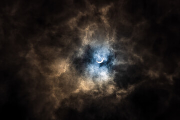 Obraz na płótnie Canvas Surreal Dramatic Solar Eclipse Covered By Clouds. Natural Phenomenon.