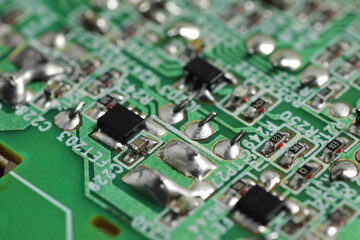 Close up shot of electronic componnents on a green printed circuit board