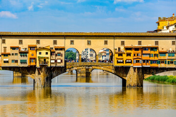 It's Ponte Vecchio (Old Bridge), a Medieval stone closed-spandrel segmental arch bridge over the Arno River, in Florence, Italy.