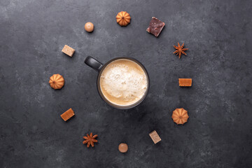 Cup of coffee and various sweets and spice on stone background. Top view. Copy space