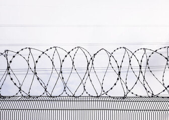 Coils of sharp razor wire on a wire mesh fence. Maximum security facility, prison, penitentiary, border control and detention concept.
Perimeter fencing for access control and intrusion prevention. - obrazy, fototapety, plakaty
