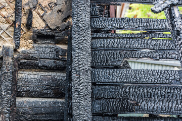 Part of the charred wooden wall of an apartment building after a fire