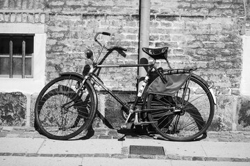 Fototapeta na wymiar Old bicycle on a brick wall background. Copenhagen. Denmark.Black and white photo. Vehicle. Transport.