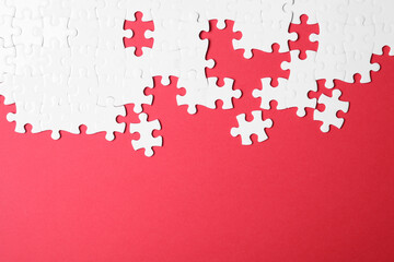 Blank white puzzle pieces on red background, flat lay. Space for text