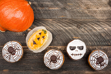 Pumpkin on old dark rustic wooden table. Halloween background with pumpkin and cakes. Autumn, halloween, party concept. Copy space, top view