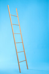 Modern wooden ladder on light blue background