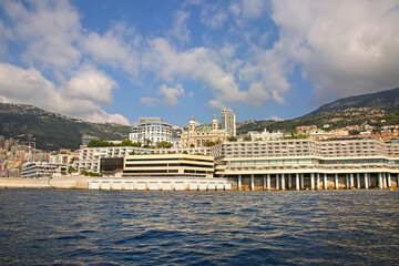 Fototapeta premium View from the Mediterranean sea of the Principality of Monaco, and Monte Carlo, with dense skyscrapers, the marina, palace & casino. 