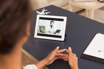 Woman talking with physician during a video call on tablet computer.