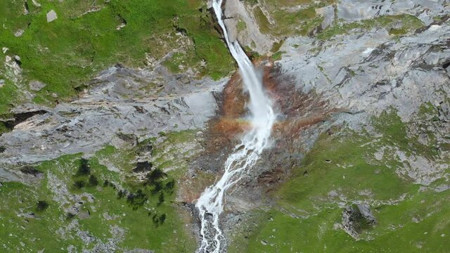 Aerial: drone flying over scenic high waterfall lush green valley and mountain stream on the italian Alps. Tourism destination hiking outdoors activity. Pis waterfall near Torino, Piedmont, Italy