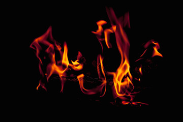 Fire flame against black background as symbol of hell and eternal pain.