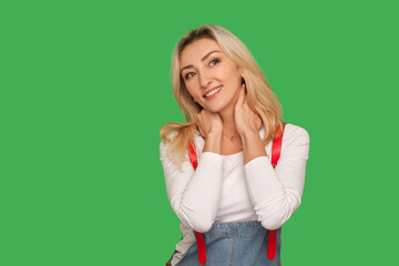 Portrait of attractive adult blond woman dreaming and smiling, thinking of pleasant happy memories with peaceful meditative face, having fantasies. indoor studio shot isolated on green background