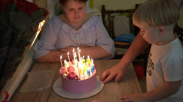 Pink cake with candles. Teenager's Birthday. Holiday cake. Candles are burning.