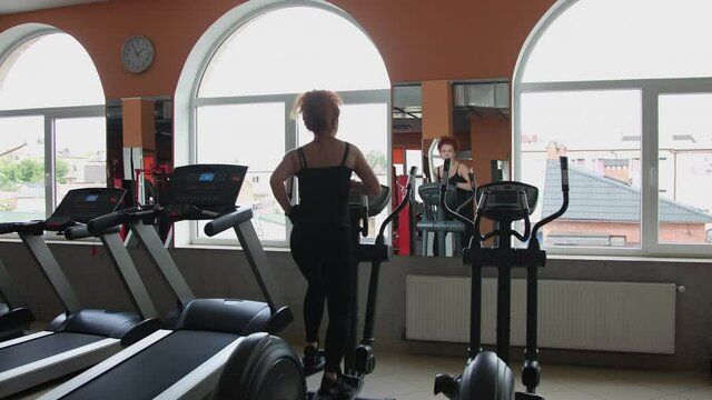 Sport girl on orbitrek. Young women does on the orbitrek at the gym