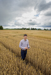 Farmer with tablet in test plots in field