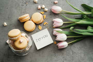 Flat Lay Background of Fresh Tulips, Yellow French Macarons and Note 